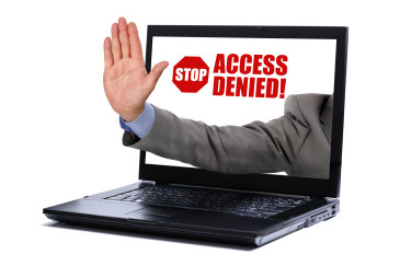 a man's hand extending from a laptop signally you to stop. 